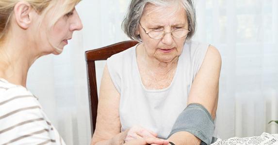 adult-daughter-checking-blood-pressure-of-elderly-mother_573x300